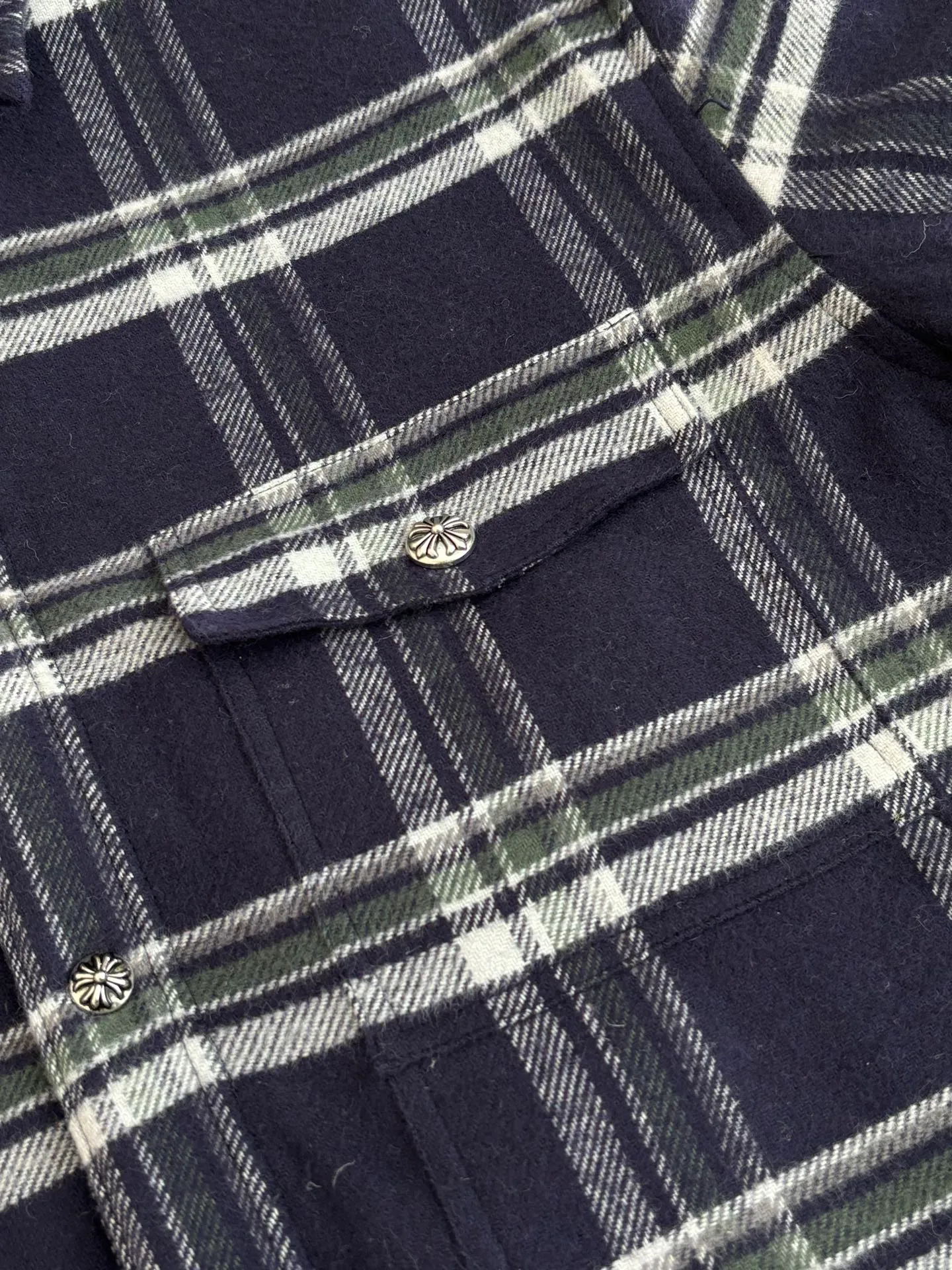 P670 Chrome Heart*/Chrome Heart Contrast Plaid Lapel Shirt Jacket. The fabric is made of 100% cotton fabric to create a navy blue main tone plaid. The rough plaid lines blend into the brand's iconic Gothic rebellious gene. The stiff cotton material supports the street silhouette, and the plush fabric inside adds softness and warmth. The collision of cold silver hardware and soft and warm inner wear is the dark aesthetic of Chrome Hearts' "symbiosis of hard core and gentleness". The autumn and winter layering has its own rock and roll accent.  Size：S/M/L/XL